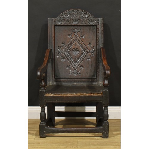 1880 - A 17th century oak wainscot armchair, carved panel back with arched cresting, downswept arms, turned... 