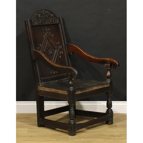 1880 - A 17th century oak wainscot armchair, carved panel back with arched cresting, downswept arms, turned... 