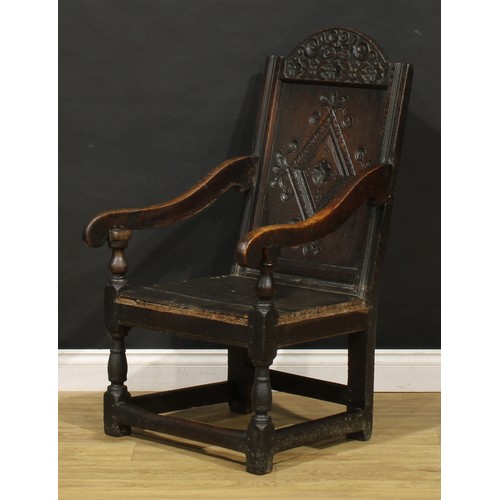 1880 - A 17th century oak wainscot armchair, carved panel back with arched cresting, downswept arms, turned... 