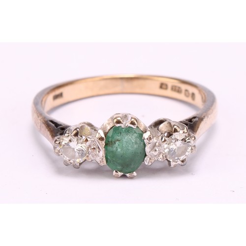 1256 - An emerald and diamond ring, central oval mid green emerald, approx 0.25ct, flanked by round brillia... 