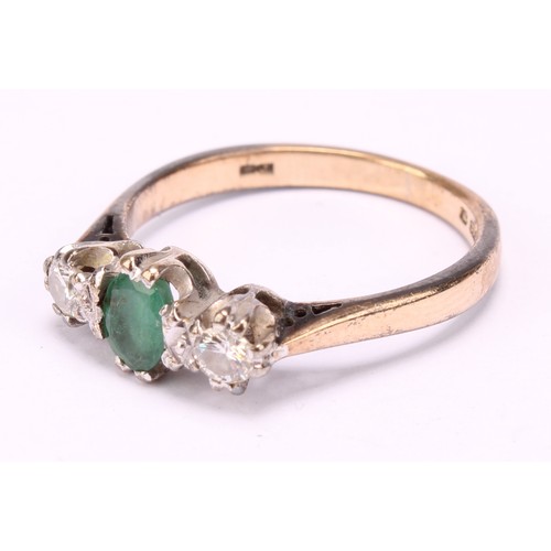 1256 - An emerald and diamond ring, central oval mid green emerald, approx 0.25ct, flanked by round brillia... 