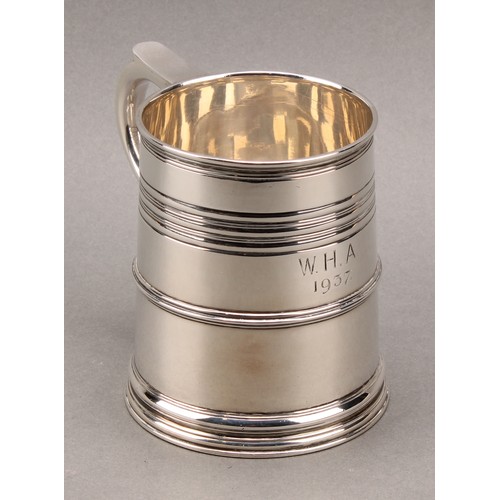 902 - A Queen Anne style silver slightly spreading cylindrical mug, moulded rim above reeded bands, skirte... 