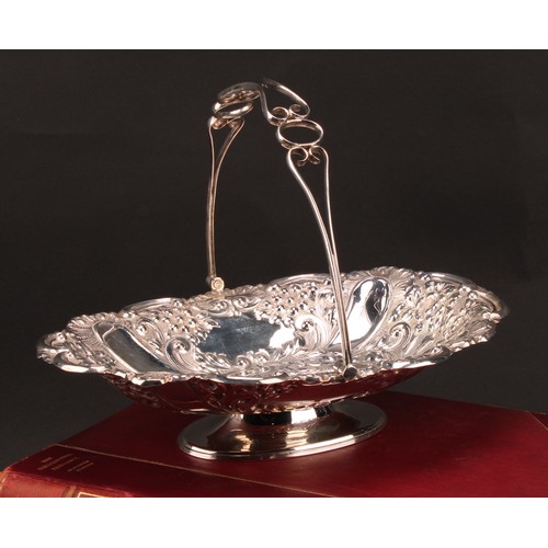 849 - A late Victorian silver swing-handled shaped oval pedestal basket, chased throughout with flowers an... 