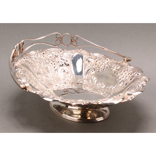 849 - A late Victorian silver swing-handled shaped oval pedestal basket, chased throughout with flowers an... 