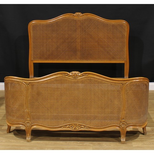 1940 - A Louis XV style corbeille bed, cane head and footboard, the headboard 122cm high, the internal 176c... 