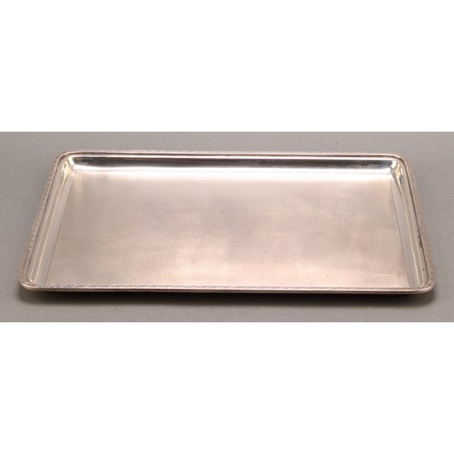 820 - A George V silver rounded rectangular dressing table tray, engine turned, 28cm wide, Mappin & Webb, ... 