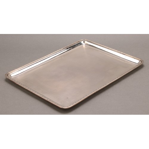 820 - A George V silver rounded rectangular dressing table tray, engine turned, 28cm wide, Mappin & Webb, ... 