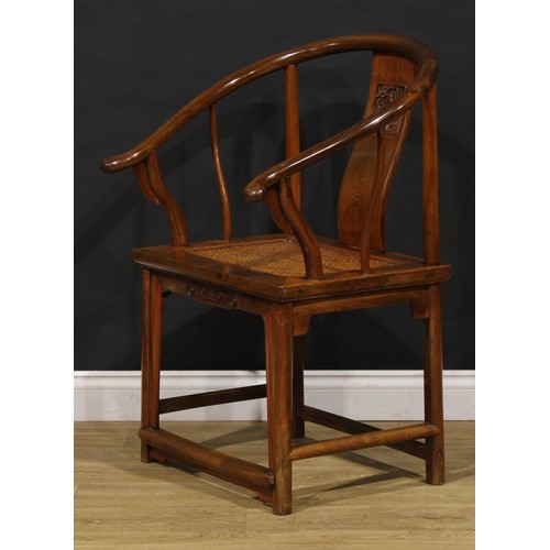 1890 - A Chinese elm horseshoe chair, the splat carved with a figure amongst prunus trees, 95cm high, 65.5c... 