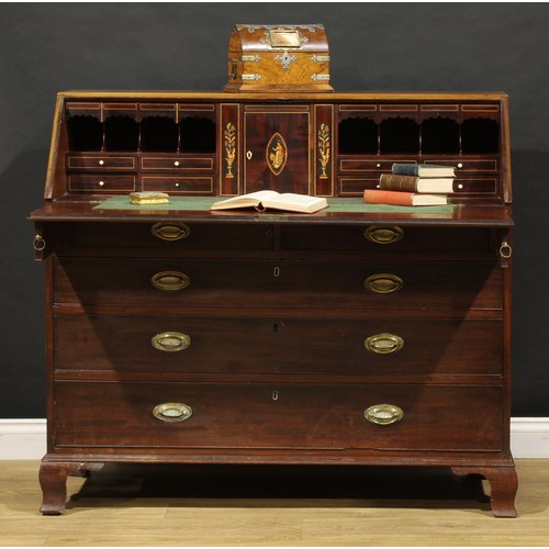 1506 - A George III mahogany bureau, fall front enclosing a fitted interior, the central door inlaid with a... 