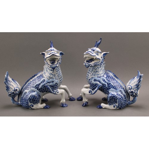 12 - A pair of Continental faience models, of Chinese Qilin, seated left and right, decorated in undergla... 