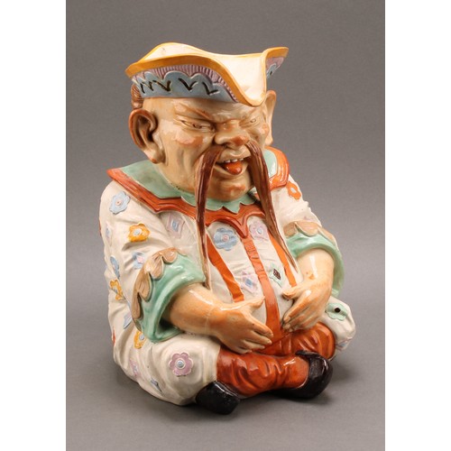 8 - A large Continental majolica character jug, as a seated Chinaman, his plaited hair as the handle, de... 