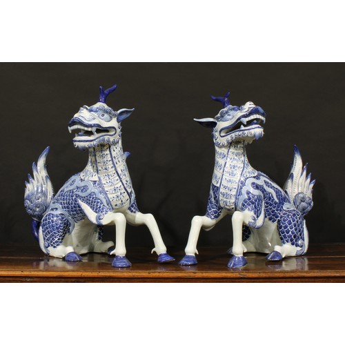 13 - A pair of large Continental faience models, of Chinese Qilin, seated left and right, decorated in un... 