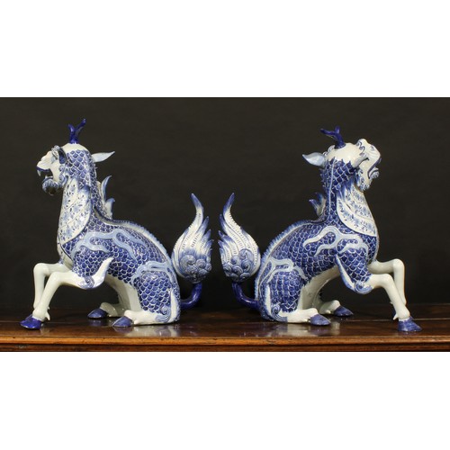 13 - A pair of large Continental faience models, of Chinese Qilin, seated left and right, decorated in un... 