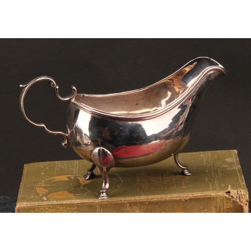 766 - A George III Irish silver sauceboat, acanthus-capped scroll handle, beaded rim, hoof feet with shell... 