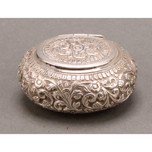 713 - A 19th century Indian silver oval snuff box, chased overall with flowers and foliage, lotus base, hi... 