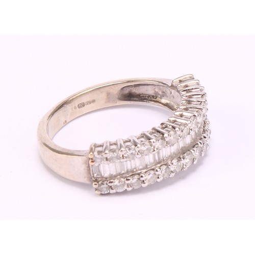 1202 - A diamond cluster ring, pave encrusted with baguette and round brilliant cut diamond arranged in thr... 