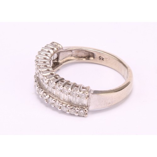 1202 - A diamond cluster ring, pave encrusted with baguette and round brilliant cut diamond arranged in thr... 