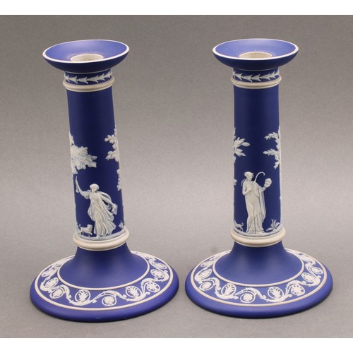 104 - A pair of Victorian Wedgwood Jasperware candlesticks, typically sprigged in white with classical sce... 