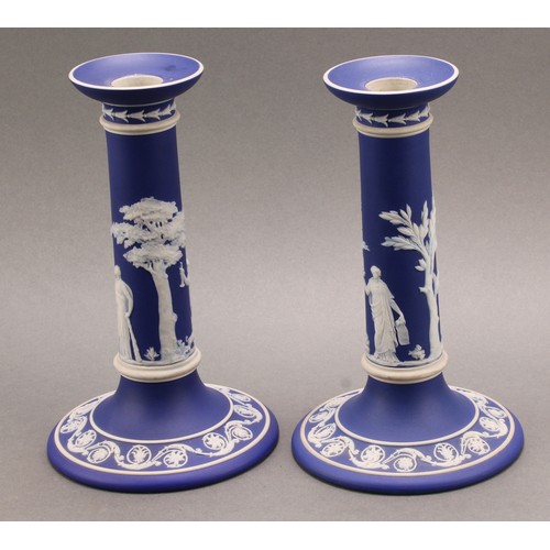 104 - A pair of Victorian Wedgwood Jasperware candlesticks, typically sprigged in white with classical sce... 