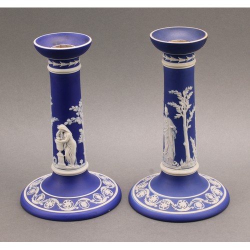 104 - A pair of Victorian Wedgwood Jasperware candlesticks, typically sprigged in white with classical sce... 