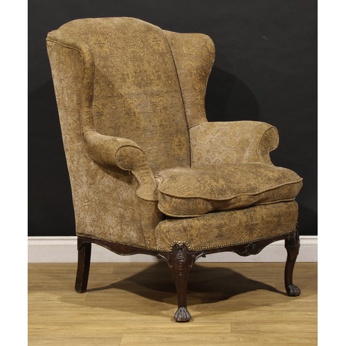 A pair of George II Revival wing armchairs, in the Irish taste, stuffed ...