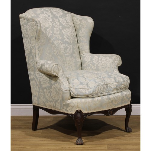 A pair of George II Revival wing armchairs, in the Irish taste, stuffed ...