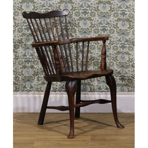 2405 - A 19th century vernacular beech, ash and elm Windsor comb back elbow chair, saddle seat, cabriole fo... 