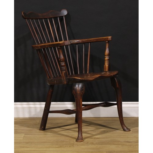 2405 - A 19th century vernacular beech, ash and elm Windsor comb back elbow chair, saddle seat, cabriole fo... 