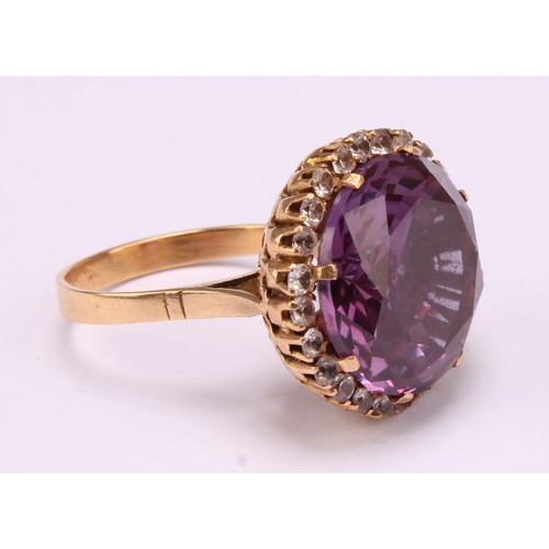 1247 - An 18ct gold synthetic purplish-pink sapphire and cubic zirconia dress ring, the centre sapphire mea... 