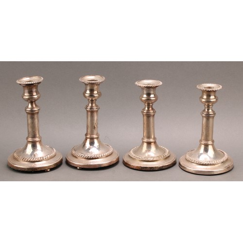 688 - A set of four silver plated candlesticks, campana sconces, removable nozzles, cylindrical pillars, s... 