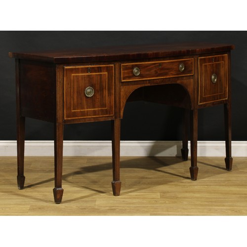 1504 - A George III mahogany bowfront sideboard or serving table, slightly oversailing top above three draw... 