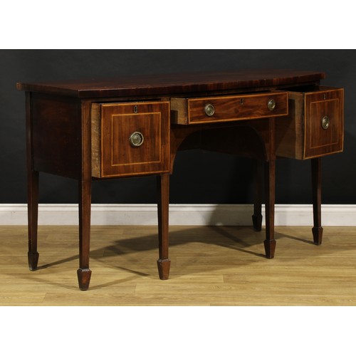 1504 - A George III mahogany bowfront sideboard or serving table, slightly oversailing top above three draw... 