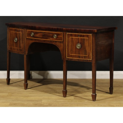 1504 - A George III mahogany bowfront sideboard or serving table, slightly oversailing top above three draw... 