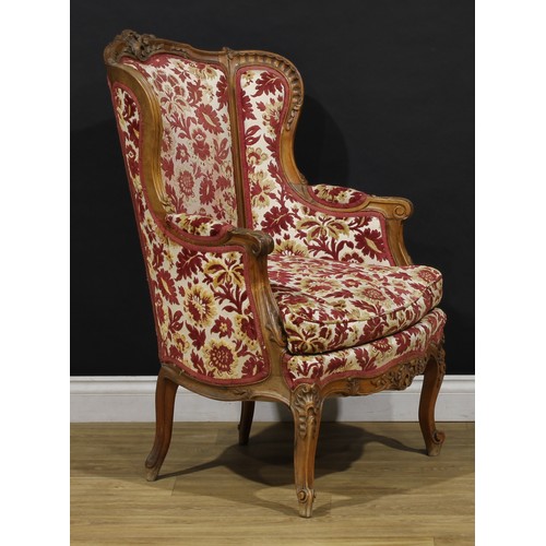 2411 - A pair of Louis XV Revival wing chairs, each with stuffed-over upholstery, squab cushion, cabriole l... 