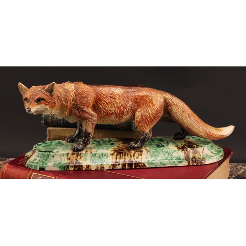 221 - A Continental model, of a fox, the base 'sponged' in mottled tones of green, yellow and brown, 36cm ... 