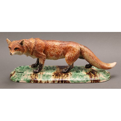 221 - A Continental model, of a fox, the base 'sponged' in mottled tones of green, yellow and brown, 36cm ... 