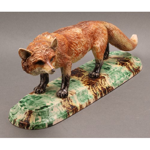 221 - A Continental model, of a fox, the base 'sponged' in mottled tones of green, yellow and brown, 36cm ... 