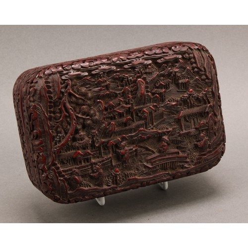 1279 - A Chinese cinnabar lacquer rounded rectangular box and cover, deeply carved with figures and pagodas... 