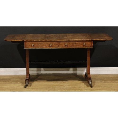 1944 - A Regency brass mounted rosewood sofa table, rounded rectangular top with fall leaves above a pair o... 