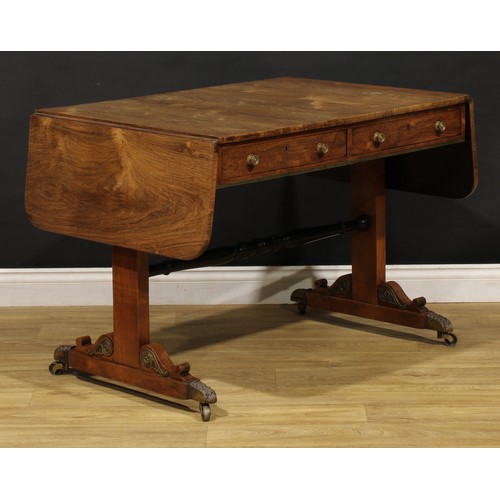 1944 - A Regency brass mounted rosewood sofa table, rounded rectangular top with fall leaves above a pair o... 