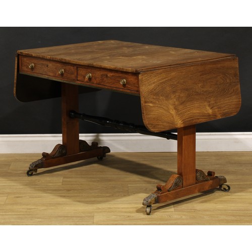 1944 - A Regency brass mounted rosewood sofa table, rounded rectangular top with fall leaves above a pair o... 