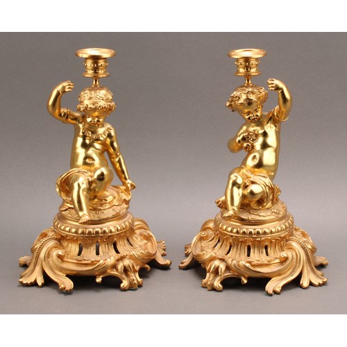 2476 - A pair of French Louis XV style ormolu single light candlesticks of bold proportions, each cast with... 