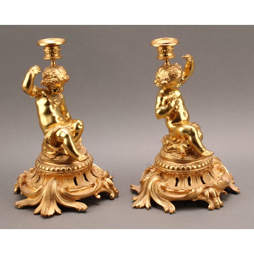 2476 - A pair of French Louis XV style ormolu single light candlesticks of bold proportions, each cast with... 