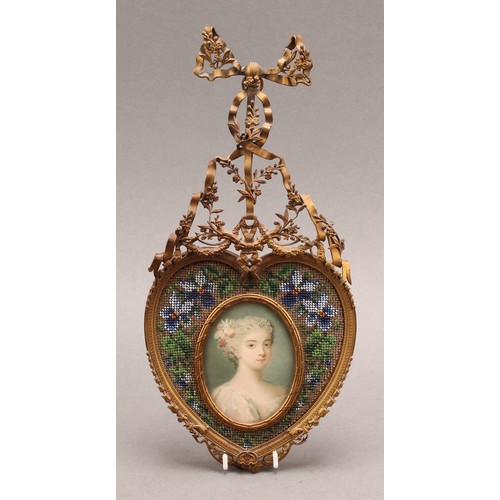 2325 - A 19th century French gilt metal and beadwork picture frame, the heart shaped frame centred by an ov... 