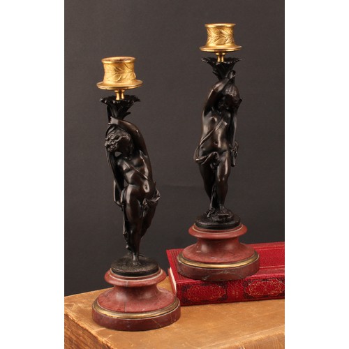 2082 - A pair of 19th century brown patinated bronze figural candlesticks, gilt sconces, turned marble base... 