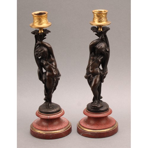 2082 - A pair of 19th century brown patinated bronze figural candlesticks, gilt sconces, turned marble base... 