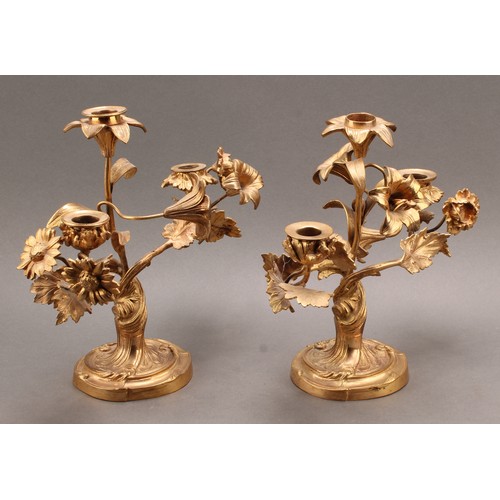 2435 - A pair of 19th century French ormolu three-light candelabra, the branches naturalistically modelled ... 