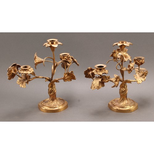 2435 - A pair of 19th century French ormolu three-light candelabra, the branches naturalistically modelled ... 