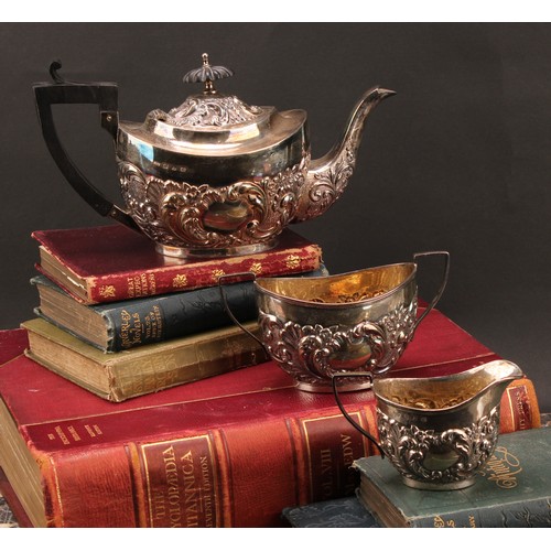 845 - A late Victorian Rococo Revival silver three-piece tea service, comprising teapot, sugar basin and c... 