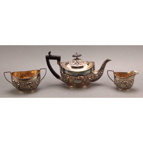 845 - A late Victorian Rococo Revival silver three-piece tea service, comprising teapot, sugar basin and c... 